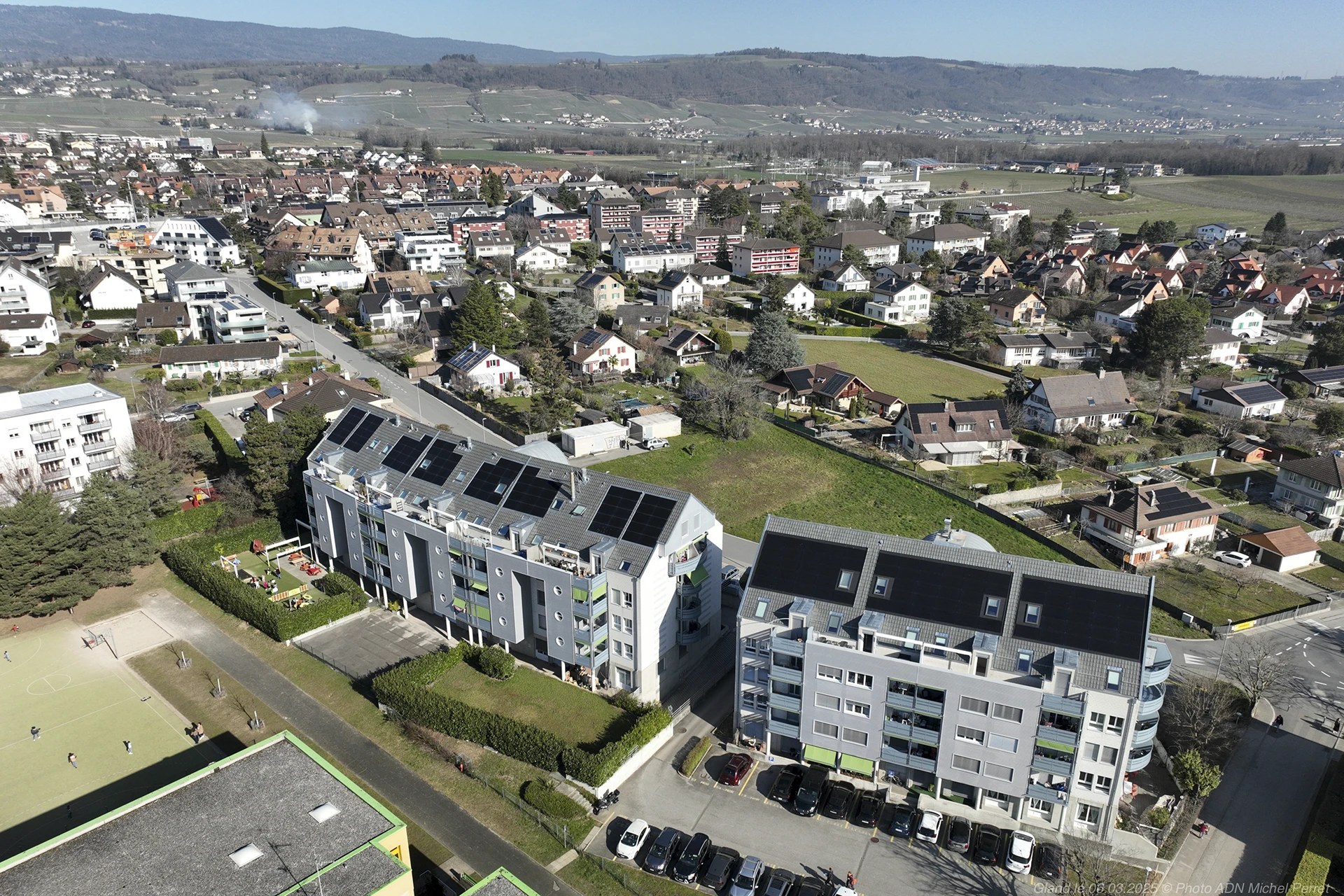 Panneaux photovoltaïques installés par Hanhart Electricité sur les toitures inclinées d’immeubles résidentiels à Gland.