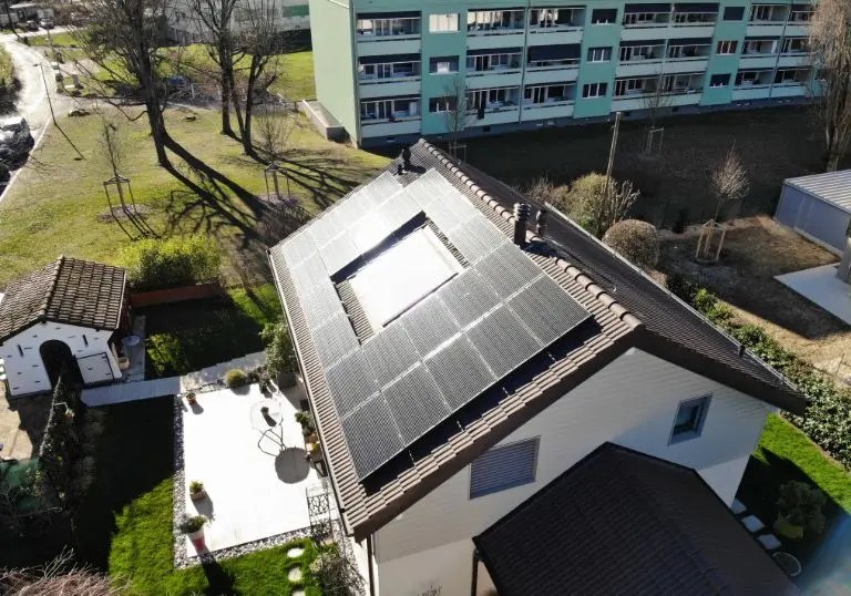 Vue aérienne de panneaux photovoltaïques en surimposition sur une maison à Plan-les-Ouates